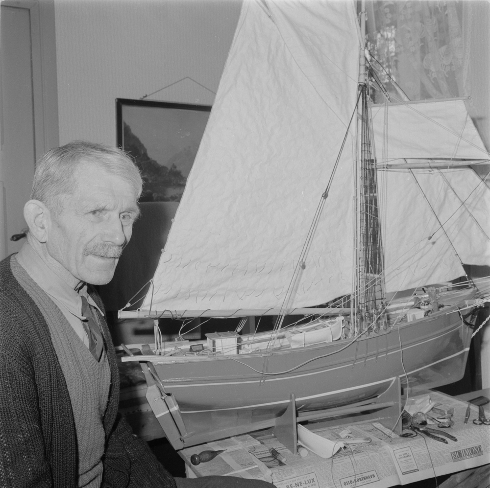 Teodor Tørrisen ved siden av modellbåt han bygger.