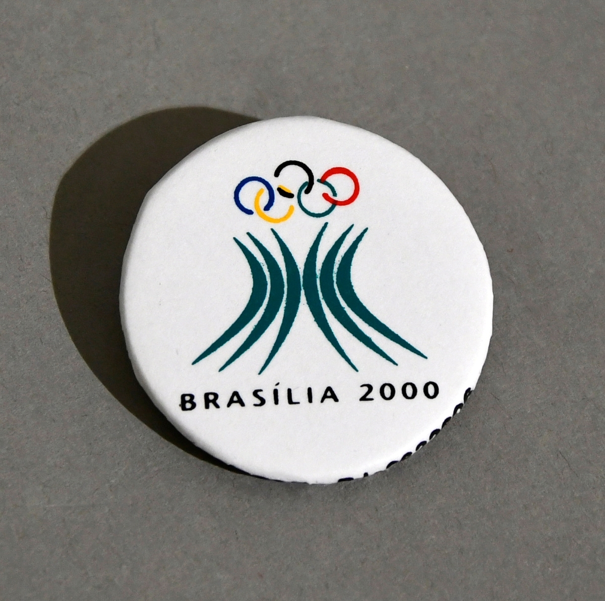 Hvit button med emblemet for søkerbyen Brasilia, for sommer-OL i 2000