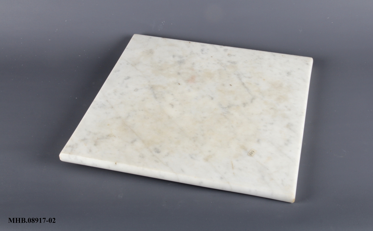 Bordplate i marmor, tilnærmet kvadratisk form.