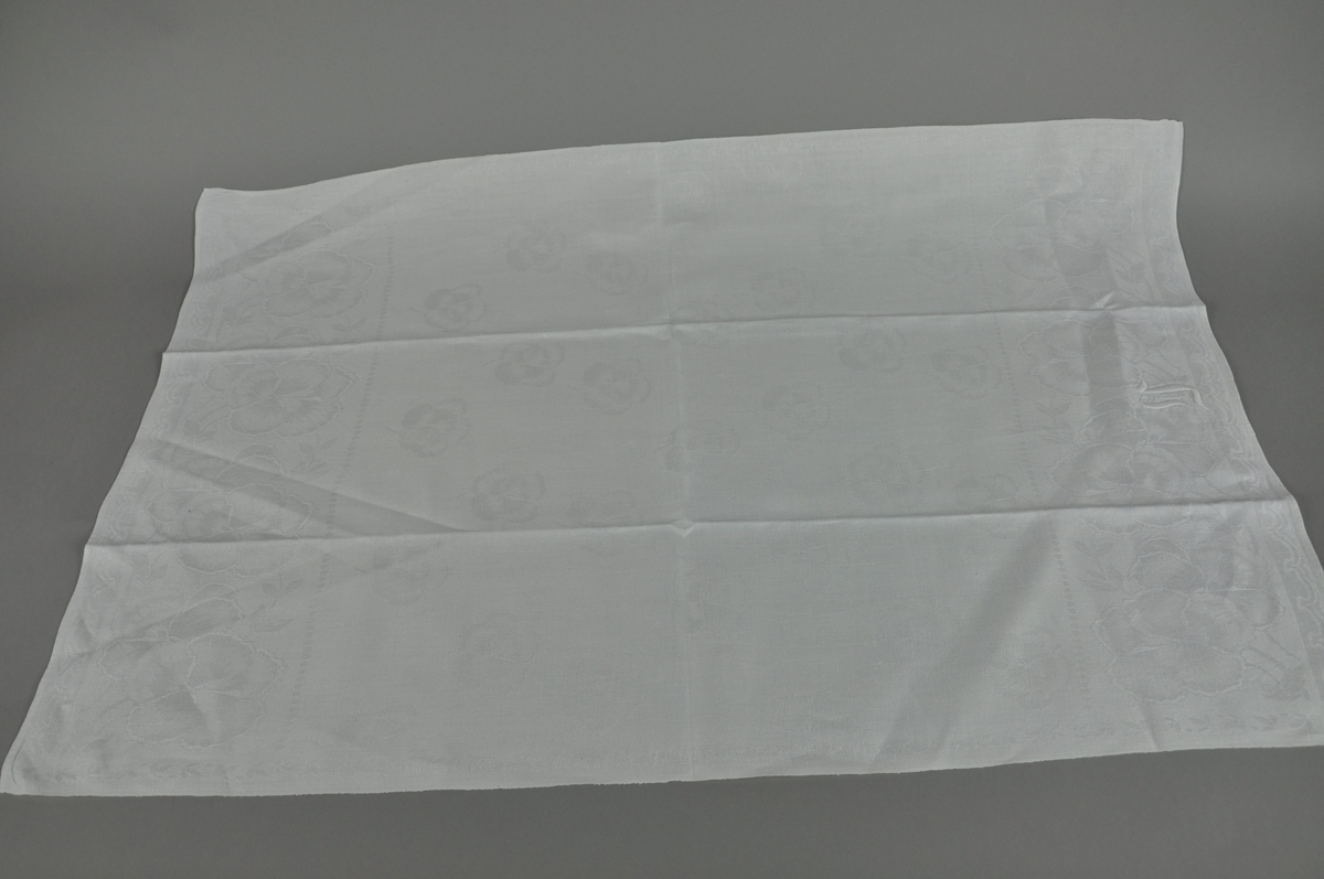 Hvitt håndkle av lin, rektangulær form.