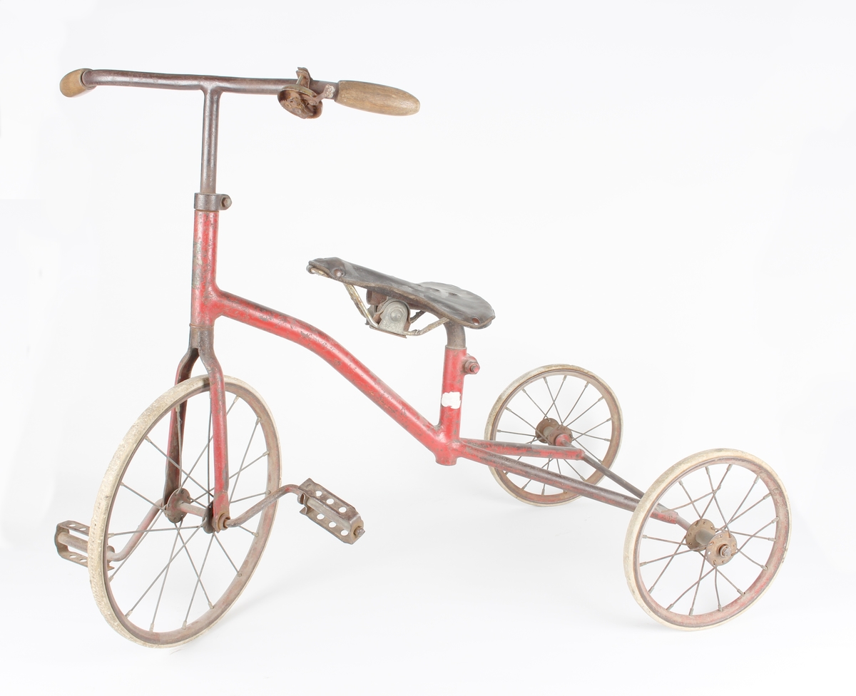 Trehjulsykkel til barn med sykkelsete av lær og ringebjelle på styret.