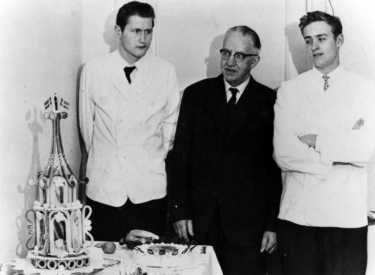 Gruppbild av 3 män. Axel Ljungblad, i mitten, är klädd i kostym medan de två yngre männen på var sida om Axel bär konditorskjorta. Bernt Ljungblad står till vänster.