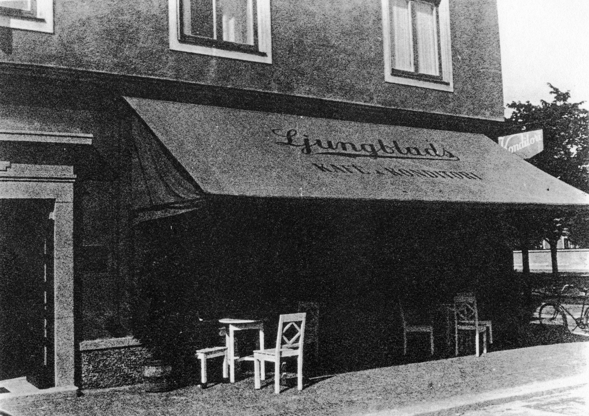Gatuvy av Ljungblads konditoris med en stor markis med text "Lingblads Kafé Konditori" som sträcker sig över uteserveringen.
Konditoriet låg senare på Lilla torget i kvarteret Pelikan.