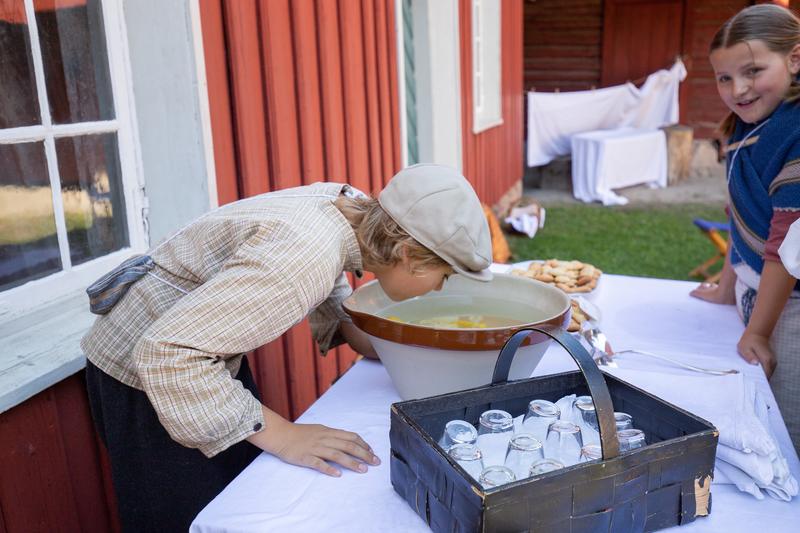 Barn på Historisk ferieskole Norsk Folkemuseum lager limonade.