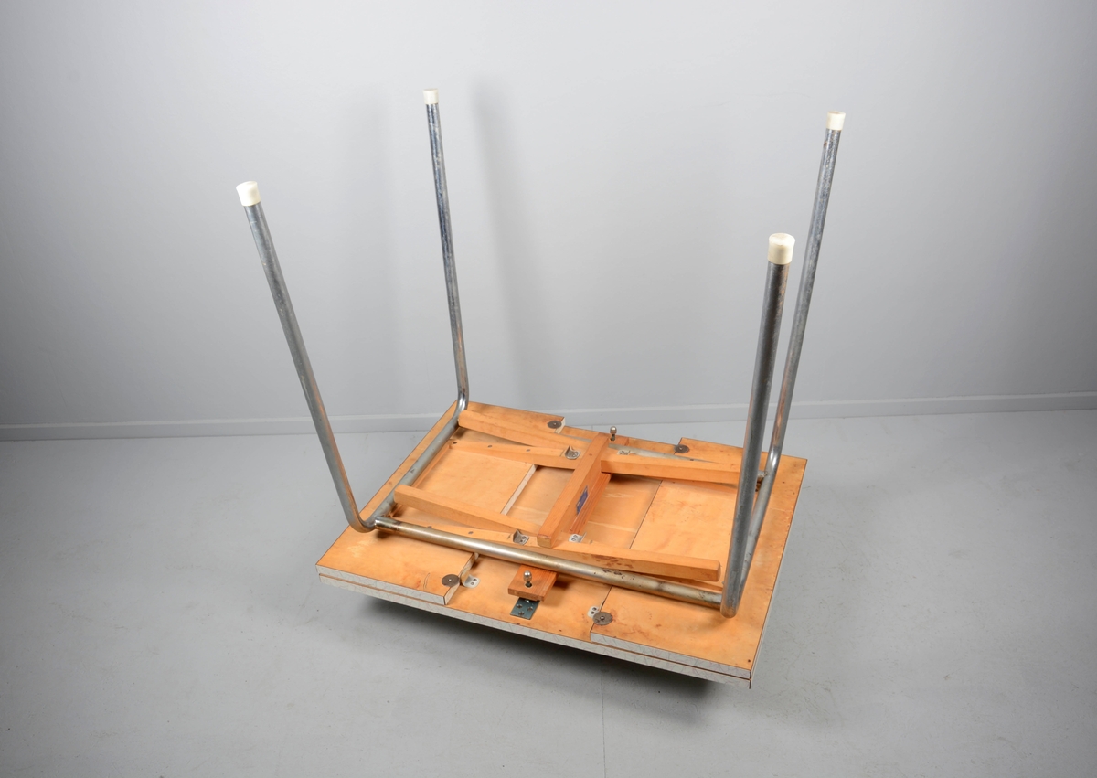 Rektangulært kjøkkenbord med to uttrekkbare sideklaffer. 4 lett skråstilte stålrørsben med plastbeskyttere nederst. Bordplate i respatex