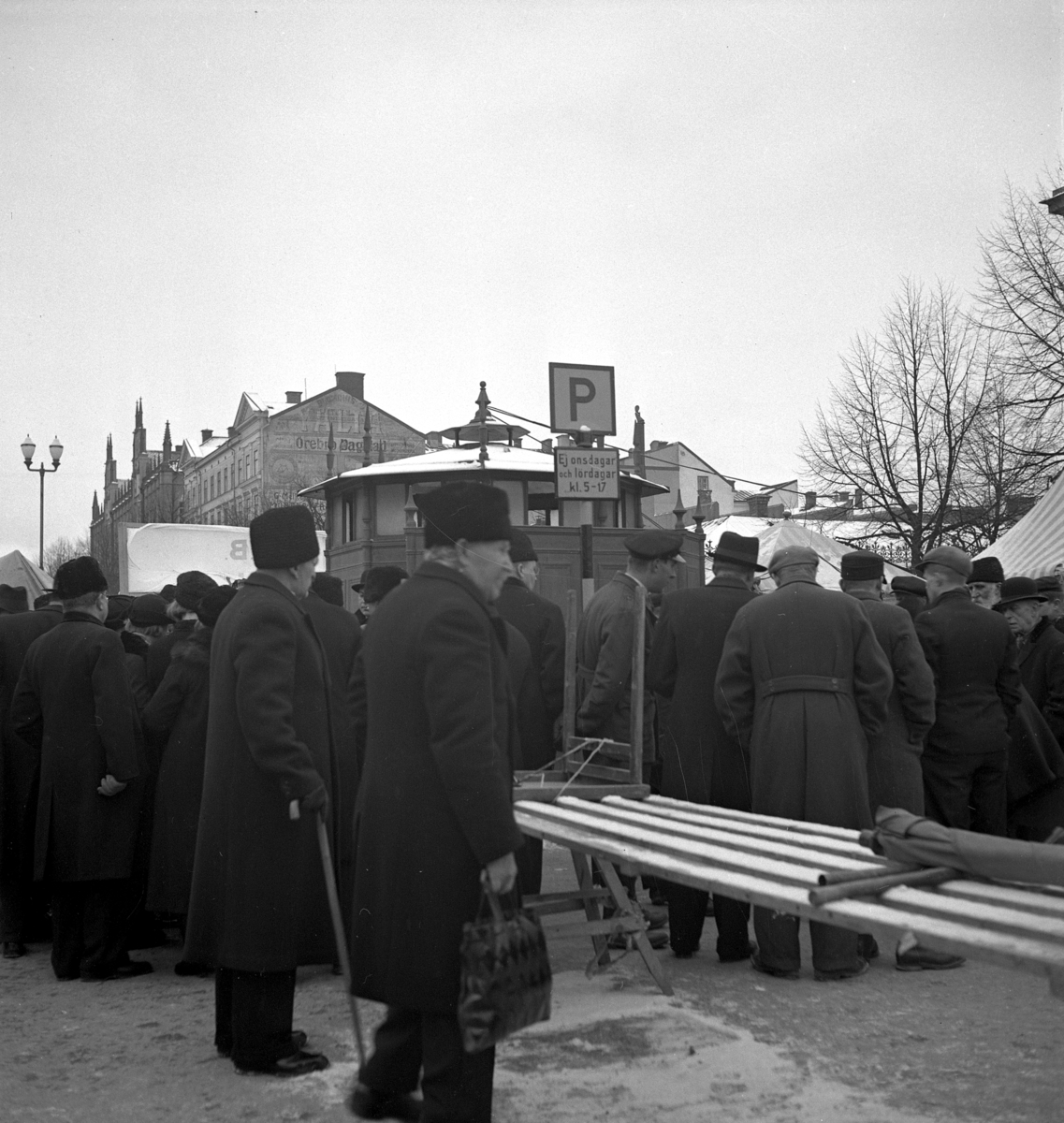 Hindersmässan i Örebro den 28 januari 1937. Full kommers pågår vid marknadsstånden på östra delen av Stortorget. Trängseln är stor.