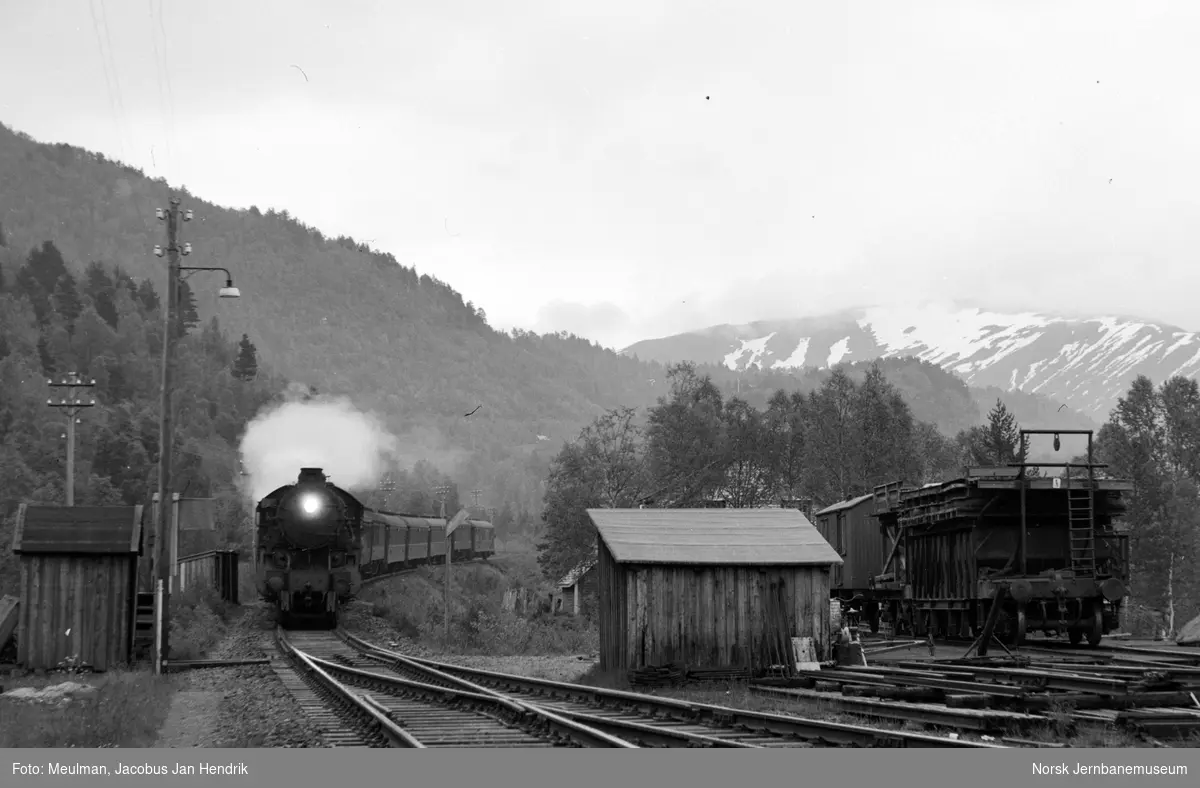 Damplokomotiv type 31b med nattoget fra Oslo Ø til Bergen, tog 605, kjører inn på Reimegrend stasjon.