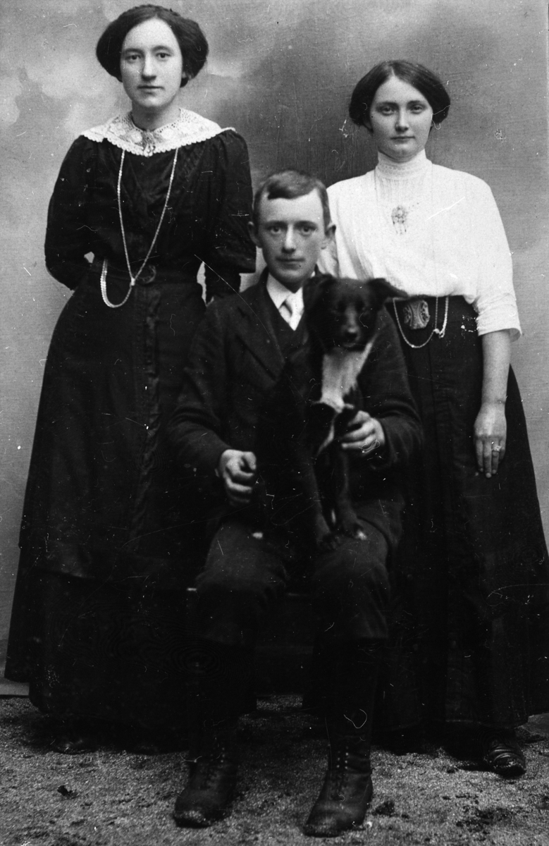 To damer bak, en mann med hund på fanget.1910.