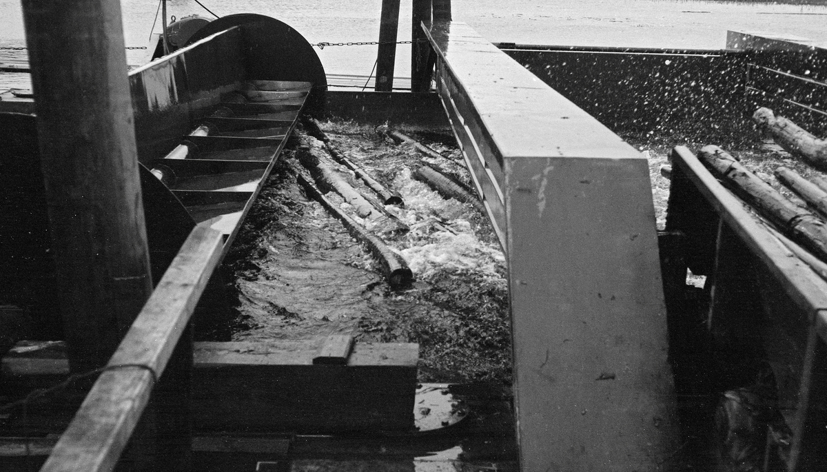 Fra Lusten lense i Klarälven i Värmland, fotografert i 1961.  Bildet er tatt ved ei bunte- eller soppemaskin, der stokkene ble ledet inn i et basseng mellom to parallelle flåteganger på pongtongunderlag. I den ytre enden av dette bassenget var det ei faststående bru med nedfelte stålbein. Høyere oppe var det også ei bru. Denne hadde i utgangspunktet oppslåtte bein, slik at tømmeret kunne flyte uhindret inn i bassenget. Når tømmermengden syntes å være høvelig for «ei soppe» (en bunt) ble beina på den bevegelige brua senket, og denne brua ble trukket – på skinnelegemer på pongtongbruene – ved hjelp av en vinsj, mot den faststående brua. På denne måten ble tømmeret presset sammen. Når det var gjort ble det knyttet en eller flere vaiere rundt de sammenpressete stokkene, som dermed var klare for sleping.  Denne soppemaskinen hadde et vaiertrekk som ble drevet av en elektromotor.  Vaieren lå an mot tømmeret, slik at tømmeret ble ledet i jevn hastighet mot bunte- eller soppemaskinen.  En liknende innretning ble installert ved Fetsund lenser i Glomma i slutten av 1960-åra.