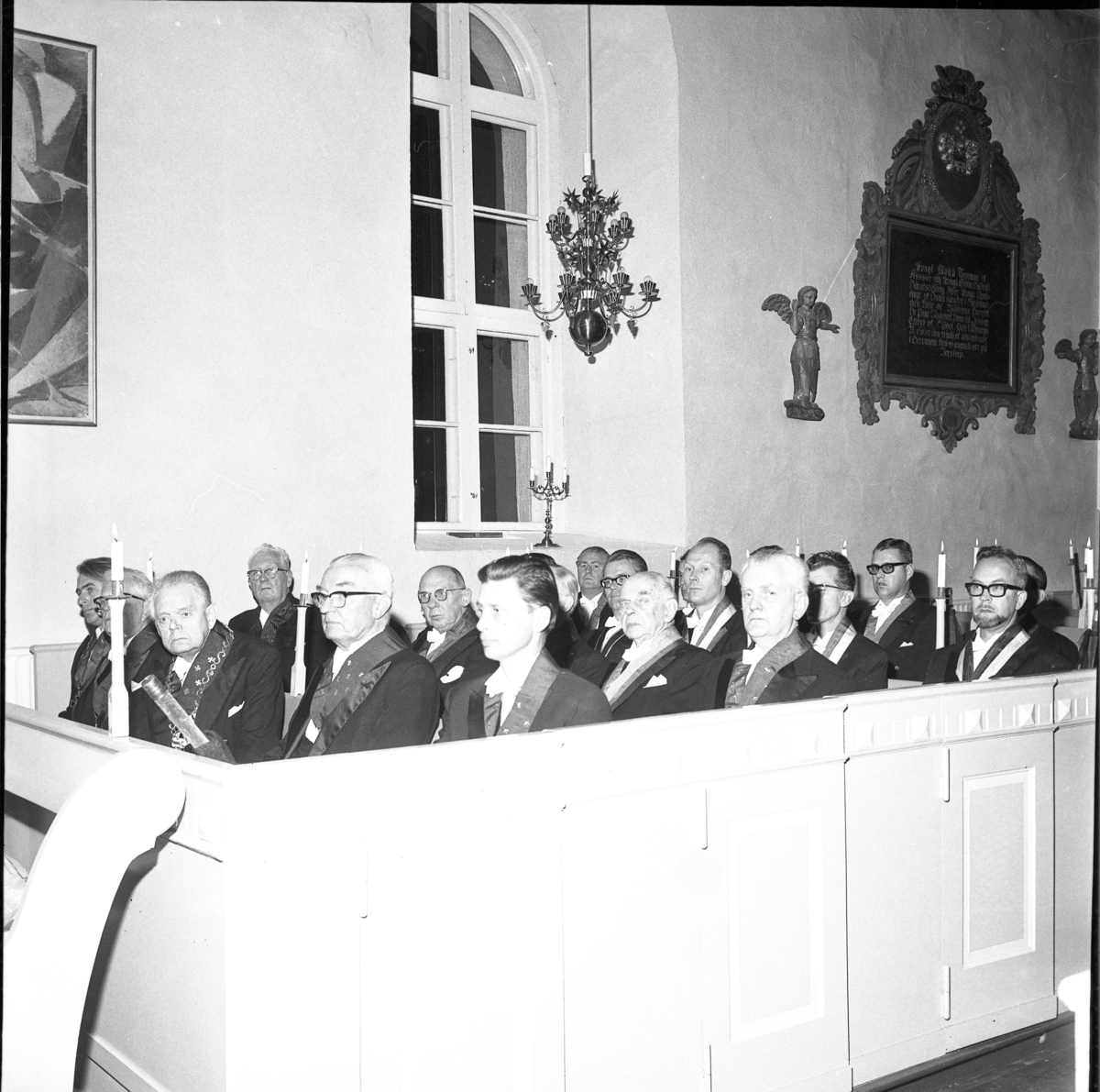 Sällskapet Par Bricole har sammankomst. Män i högtidsdräkt sitter i Järstorps kyrka.