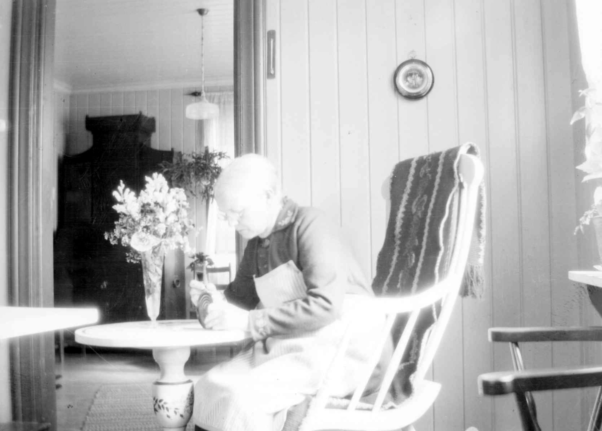 Interiør, med Agnethe Jørstad (1862-1947). i gyngestol.