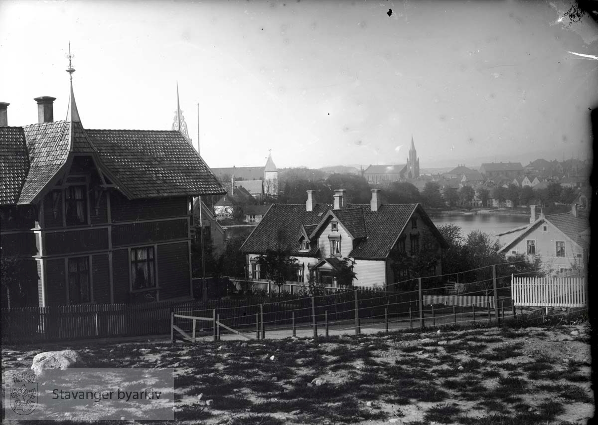 Utsikt fra St. Olavs gate mot nord-øst. Huset til venstre er Kannikbakken 4 og 2 i midten. Muségaten 2 til høyre. Breiavatnet, Domkirken og Petrikirken i bakgrunnen. .Villa i sveitserstil.