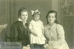 Gunhild Pedersen som liten flankert av to kvinner