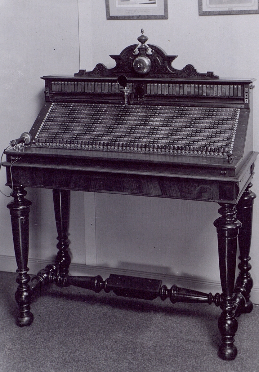 Växelbord, LME-tillverkat i början av 1880-talet. Med metallskenor och lösa proppar, fast mikrofon och hörtelefon.