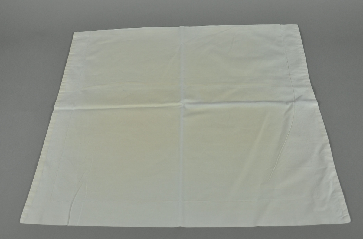 Hvit tekstil, rektangulær form.