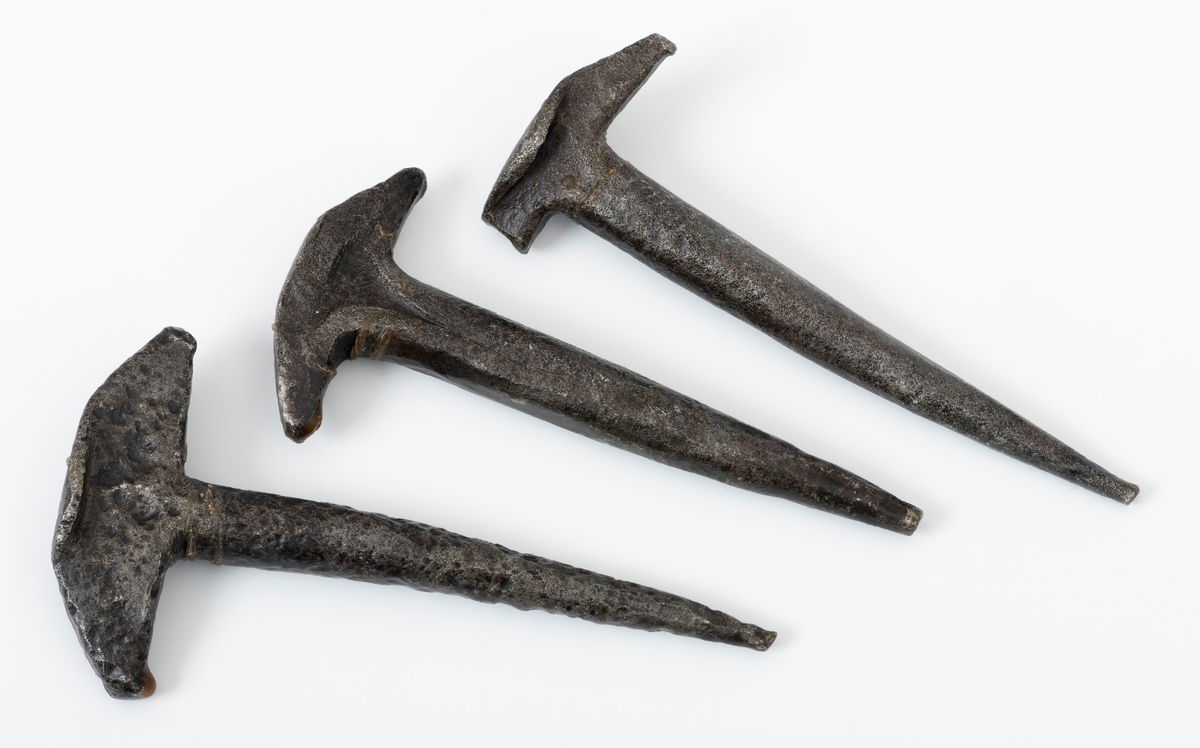Tre T-formete pjakser, haker eller nåler i jern brukt til å feste tømmer med kjetting til kjøreredskap, særlig lunneredskap.