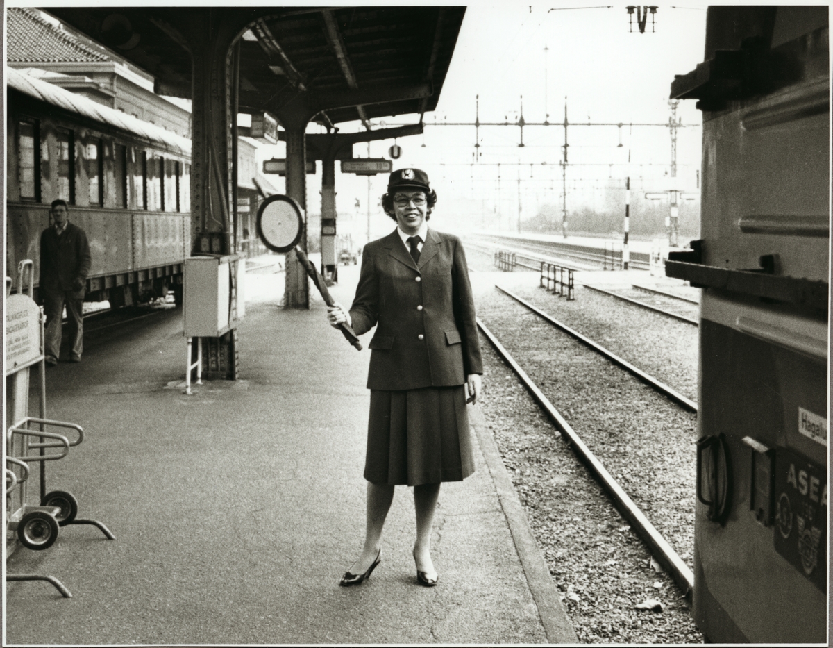 Ingeborg Jacobsson med signalstav, den första kvinnliga tågklareraren hos Trafikaktiebolaget Grängesberg - Oxelösunds Järnvägar, TGOJ på Centralstationen i Eskilstuna 1981.