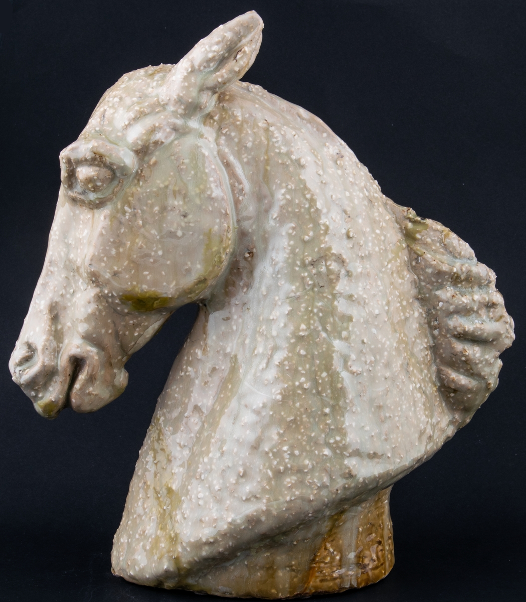 Modellerad figurin i stengods, föreställande ett hästhuvud. Utförd som ateljéproduktion av Lillemor Mannerheim 1956 eller 1957 som förlaga till den formgjutna figurinen Hästhuvud som producerades av Gefle 1957-1964.