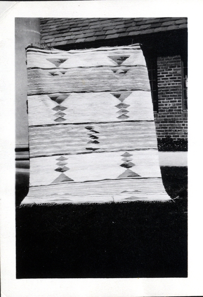 Foto (svart/vitt) av en "trasmatta" (röllakan?) som visas upp utanför Cranbrook College of Arts, Michigan,
USA, ca 1930-31. 

Inskrivet i huvudbok 1983.