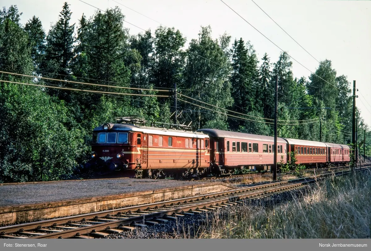 Elektrisk lokomotiv El 11 2105 med hurtigtog fra Skien til Oslo V på Vakås holdeplass.