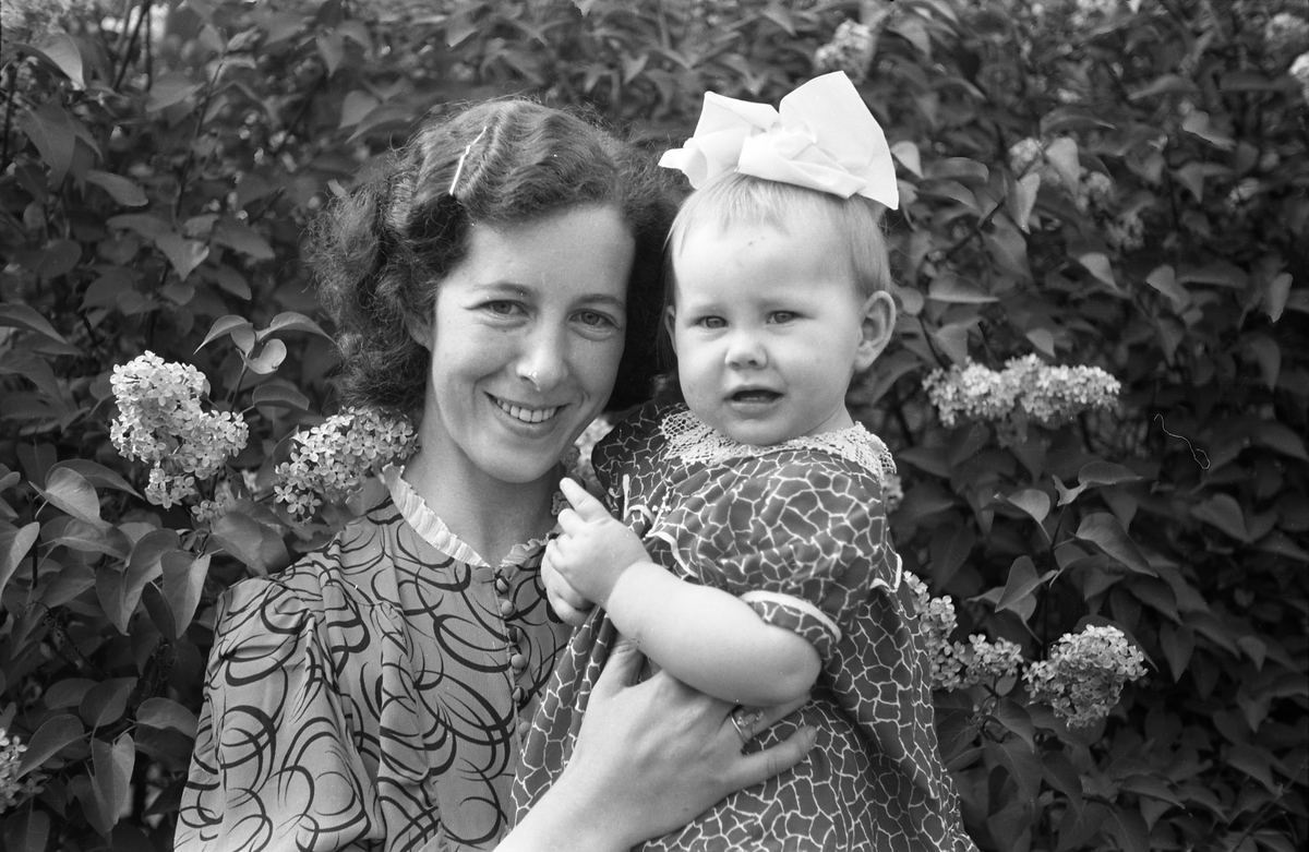 To portretter av kvinne med et jentebarn på armen. Antatt Mally Tallerud og dattera Marit ca. 1943.