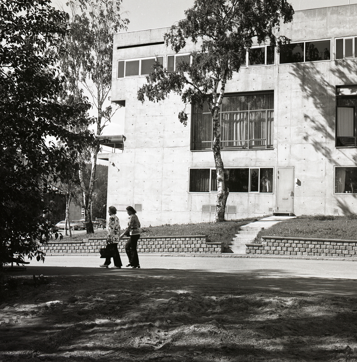 Två kvinnor på promenad utanför en byggnad i Örnsköldsvik, 19 juli 1974.