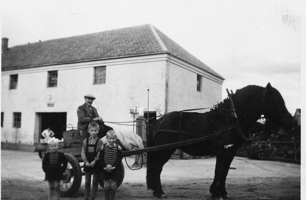 Severin Skårland med hest og mjølkekjerre framfor meieriet på Undheim i slutten av 1940 åra. Ein del bønder frå same krinsen ordna seg slik at dei frakta mjølka kvar sin gong.