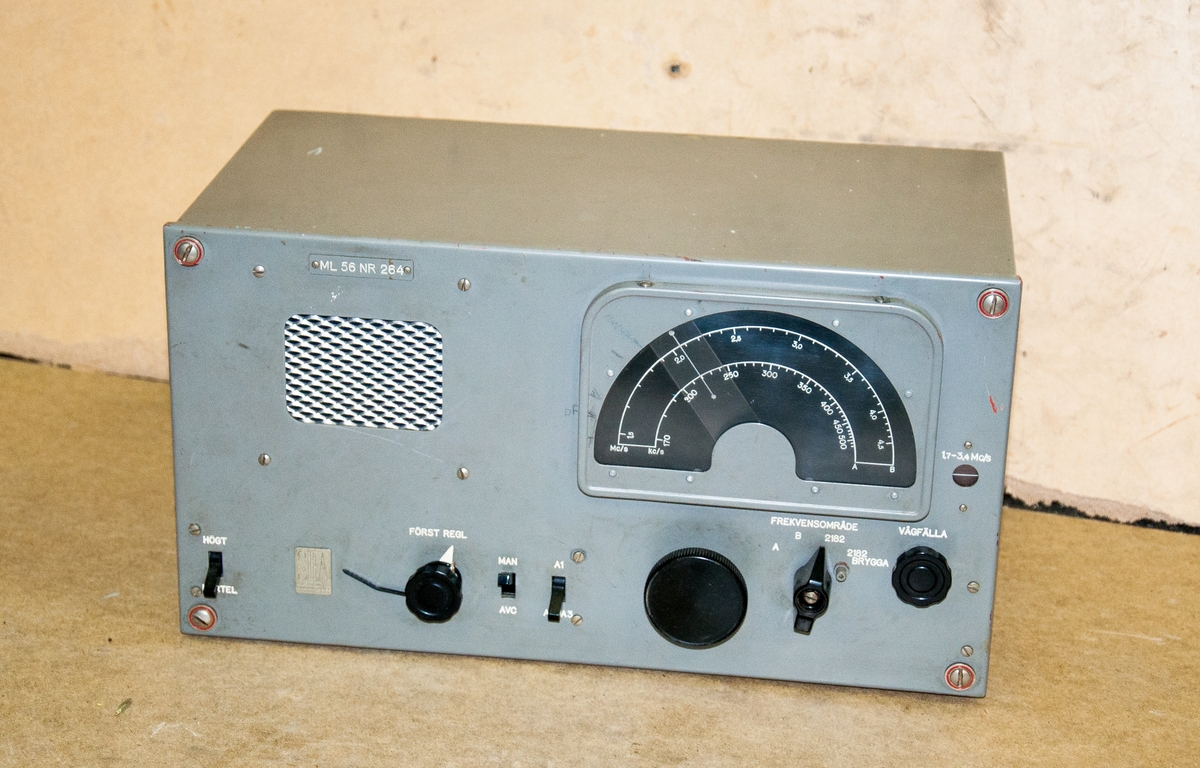 Marin radiostation, tre detaljer, med radiorör och mikrofon. 
Sändare AKH-4E, nr142. 
Mottagare ML-56, nr264 samt AKH-4P,nr500, Vikt: 72,0 + 70,0 + 13,0 kg, med
Telefonlur/mikrofon på väggfäste märkt: "Televerket långtongivare 06-16289 mått:L-95mm, B-88mm, H-150mm, kontakten på luren märkt: "microtelefon 06-12050 mikr. 35ohm"