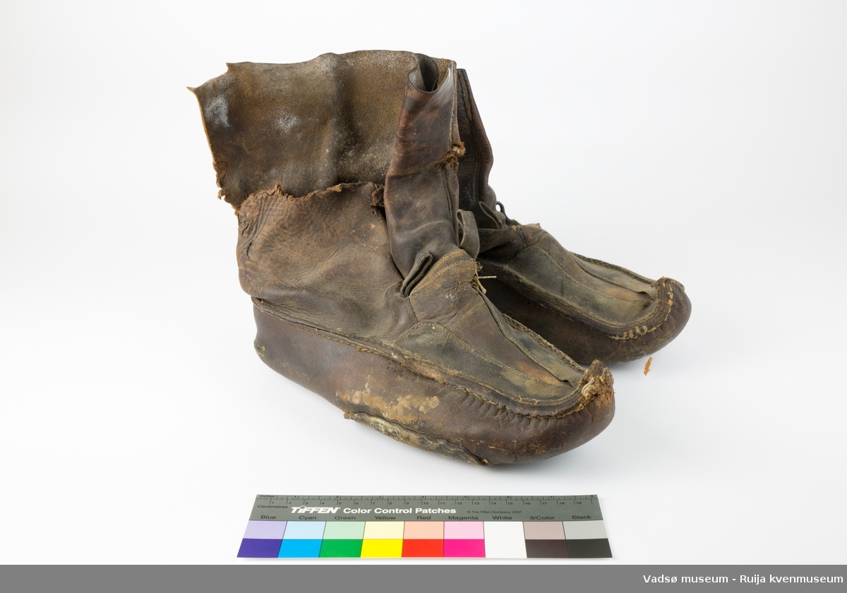 Brune lærsko av typen biekso (samisk). Den ene skoen er reparert under med påsydd lærlapp. Denne mangler også en del av ytterlæret høyere opp på skoen.