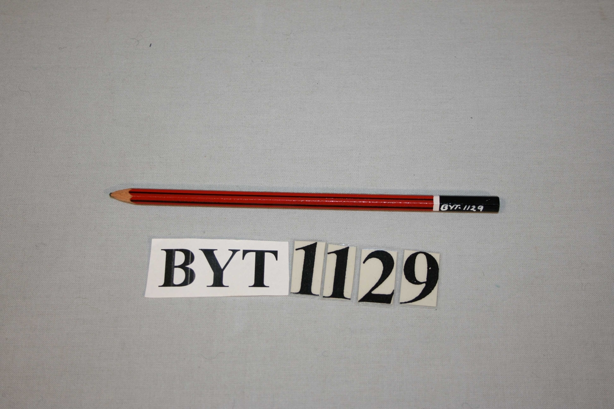 6-kanta blyant med raud botnfarge.