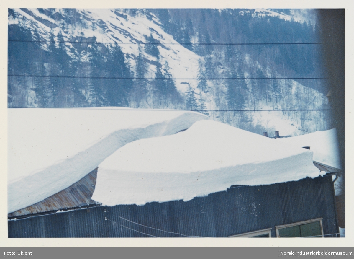 Snø på vei ned fra taket på lageret i Sam Eyges gate 59 på Rjukan