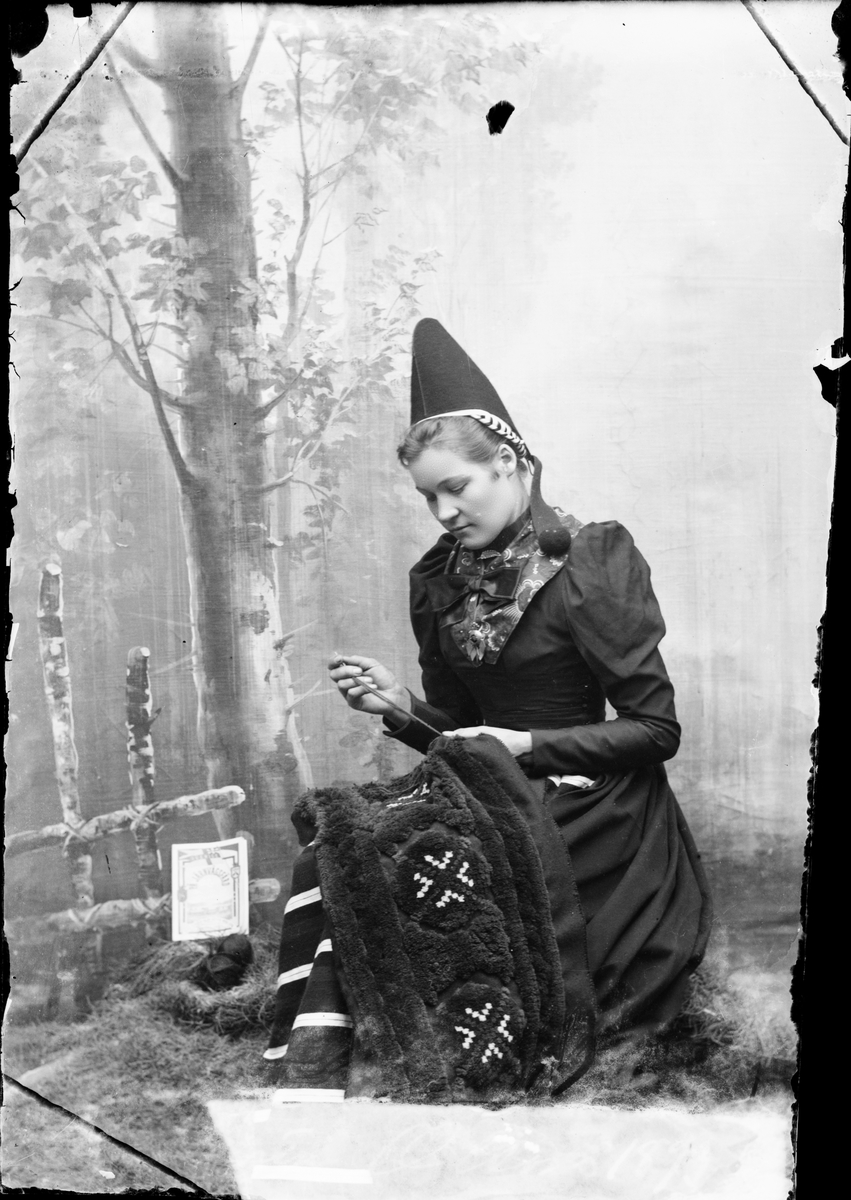 Ateljéporträtt - kvinna klädd i folkdräkt från Dalarna 1893