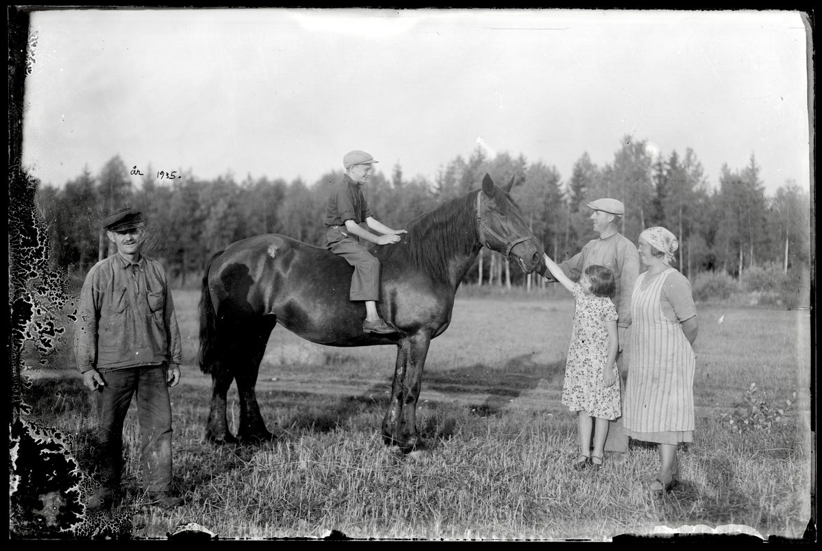 Familj och pojke på häst