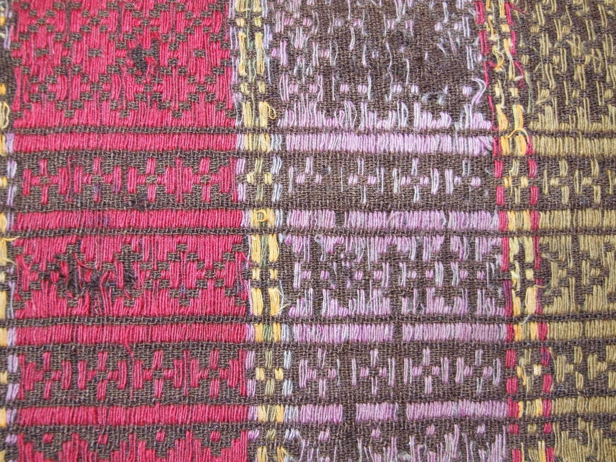 Teppe, del av kristneteppe, vevd i skillbragd. Klåre fargar. Truleg syntetisk farga. Mønsteret er ikkje symetrisk på midten, og teppet er slik truleg vevd på ein vev sett opp med tanke på at to stykkjer skulle setjast saman til eit breidt teppe.