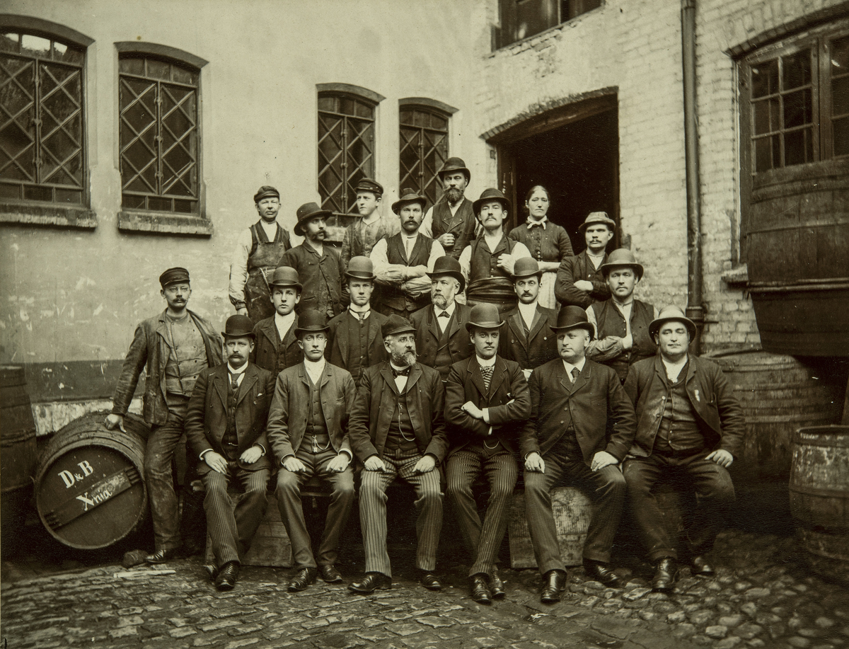 Damman og Baltzersens eiere og personal, 01.08.1891. 
Bildet er tatt på gårdsplassen i Kongensgate 4 i Kristiania. 

