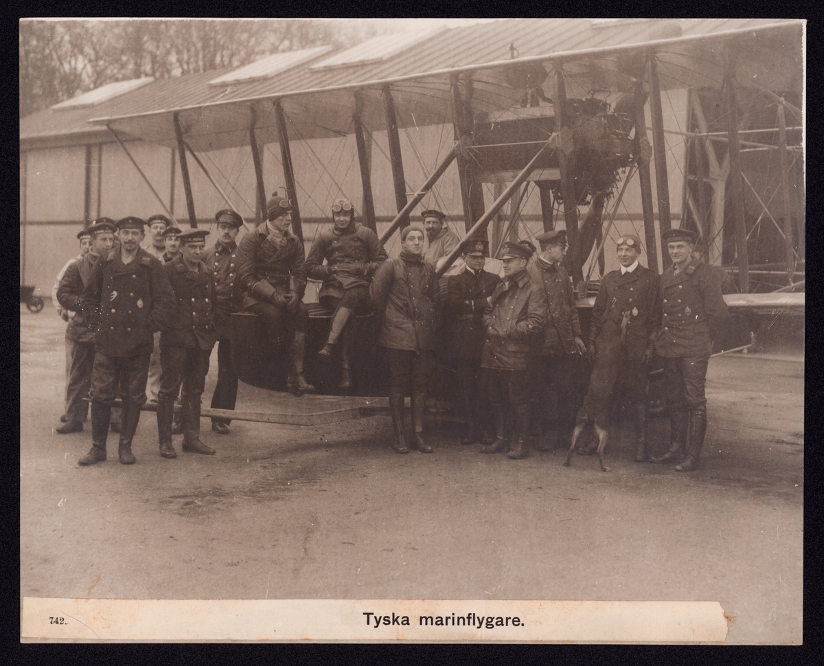 Bilden visar en grupp tyska marinflygare som har tagit uppställning för fotografering vid ett sjöflygplan.