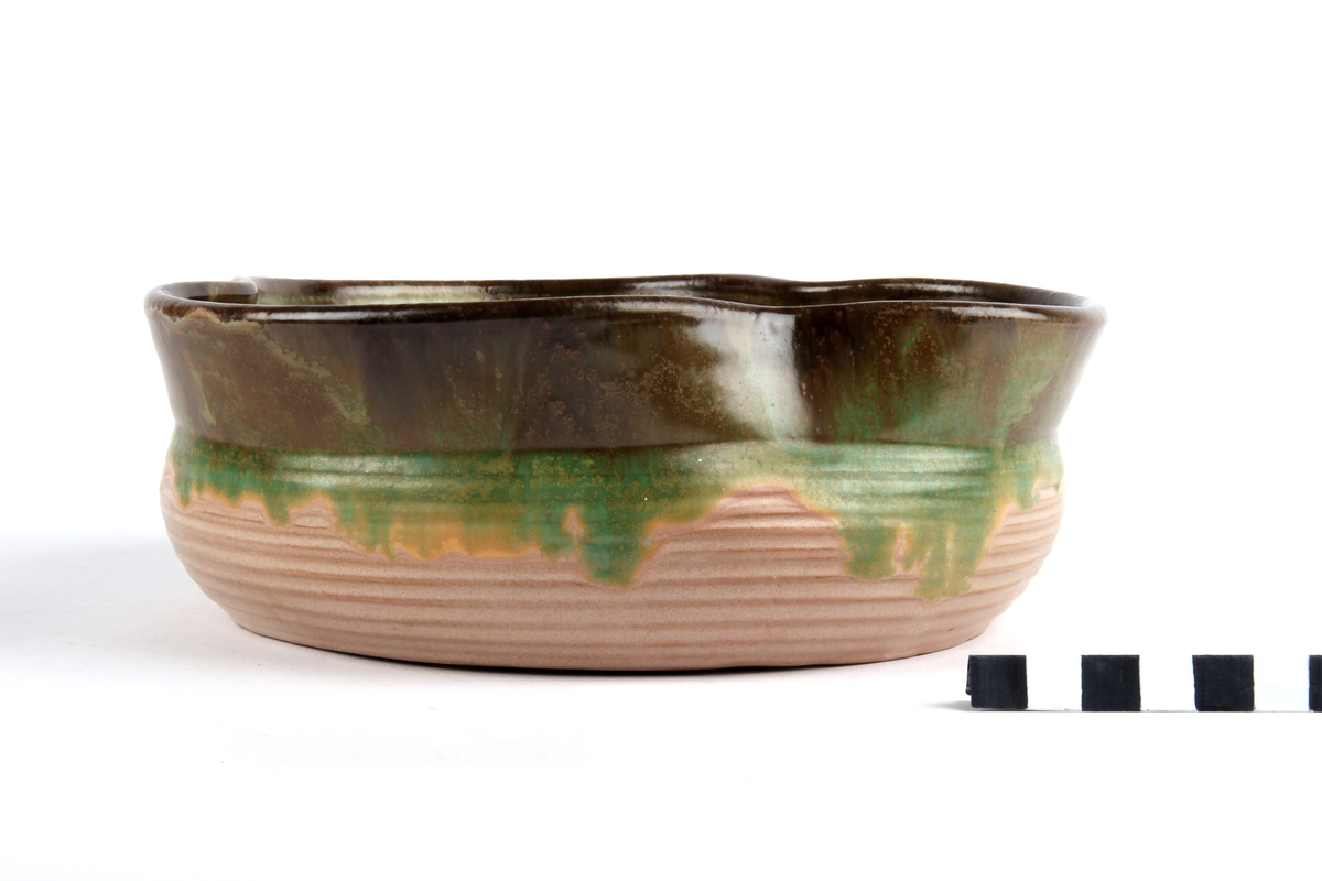 Glasert keramikkskål med utvendige riller og bølget kant.