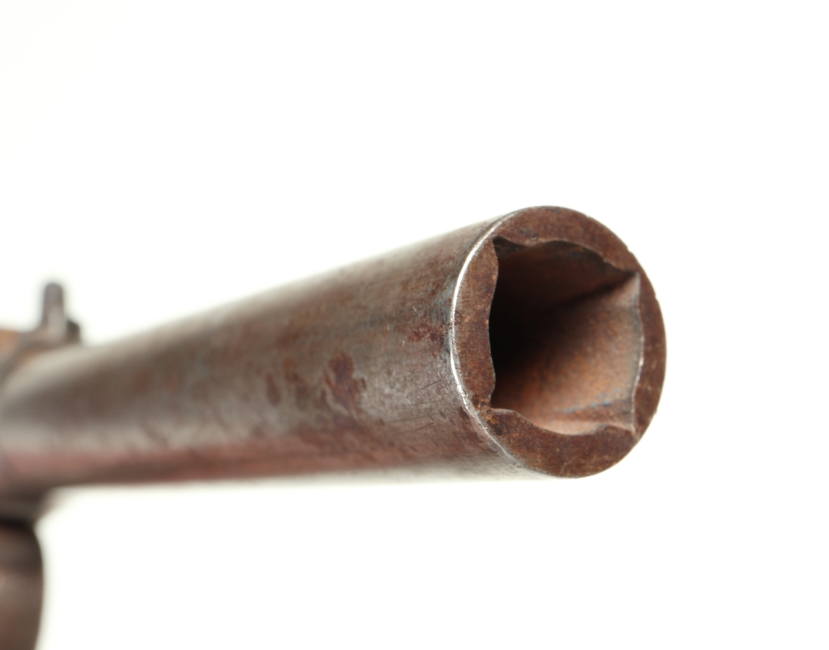 Liten slaglåspistol med pipa och varbygel i stål. Kolven har en rund form och betsad Mekanism saknas dock. Pipan är räfflad med en innerdiameter på ca. 11 mm. 
Inskrivet i huvudkatalog 1954.
