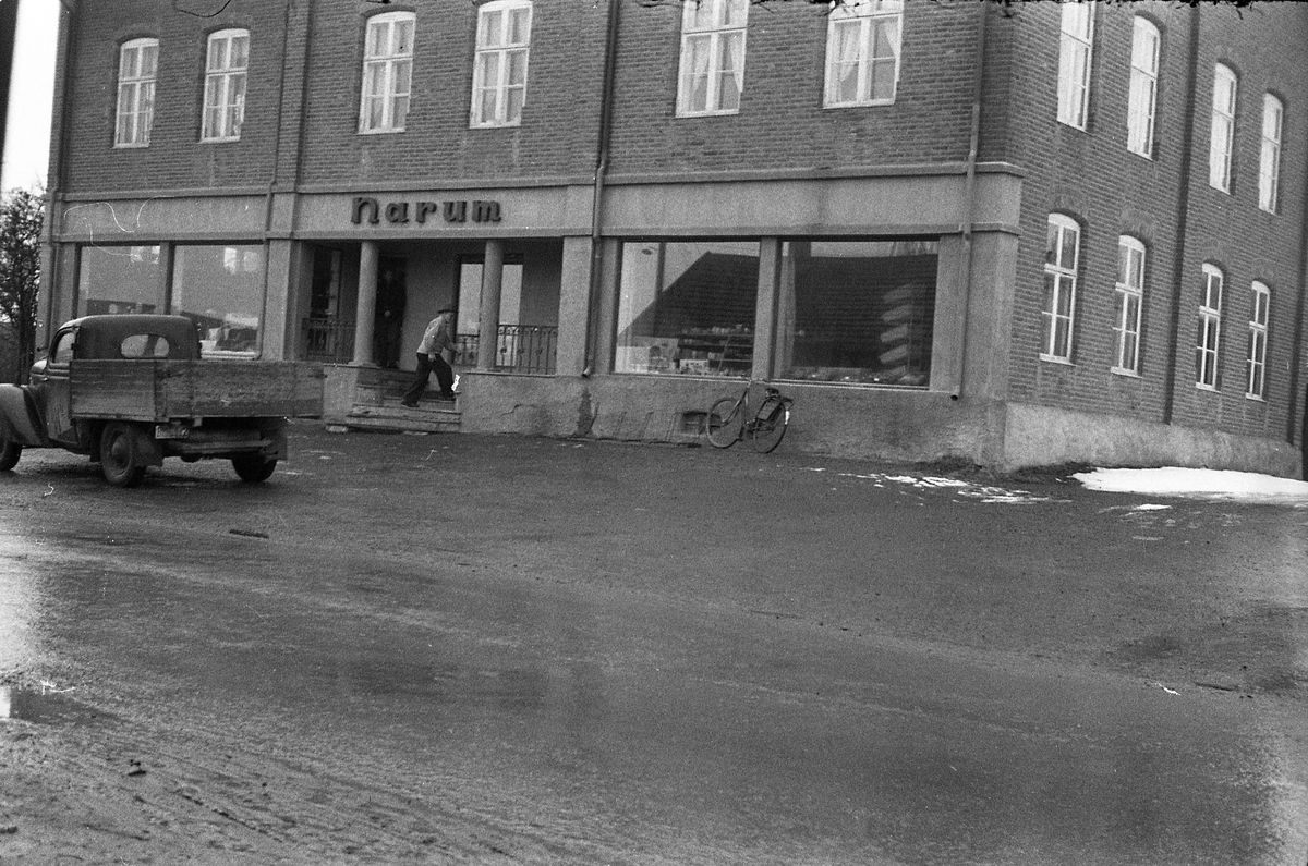 Narum-butikken på Lena våren 1961. Ifølge informant er bilen til venstre i bildet trolig en førkrigs amerikansk personbil som er ombygd til pickup.