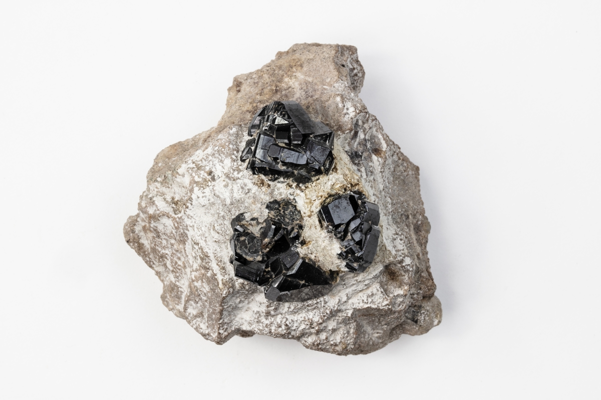Ett mineral som består av tenndioxid. Mineralet bildar tetragonala kristaller, vanligtvis i svart eller brunt. Detta exemplar kommer från dåvarande Böhmen i Österrike/Ungern och ingår i Adolf Andersohns samling.