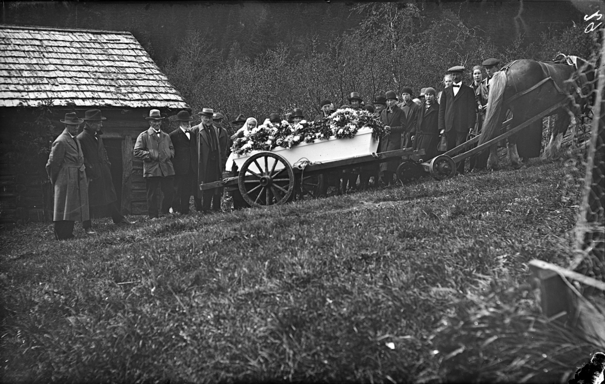 "Gravølet etter Kristine Paalsrud, våren 1929". Kristine var Kristine Olsdatter Høgsveen (1912-1929), som døde på Pålsrud, Rudsbygd (Fåberg) Kisten trekkes av hest med kjerre.