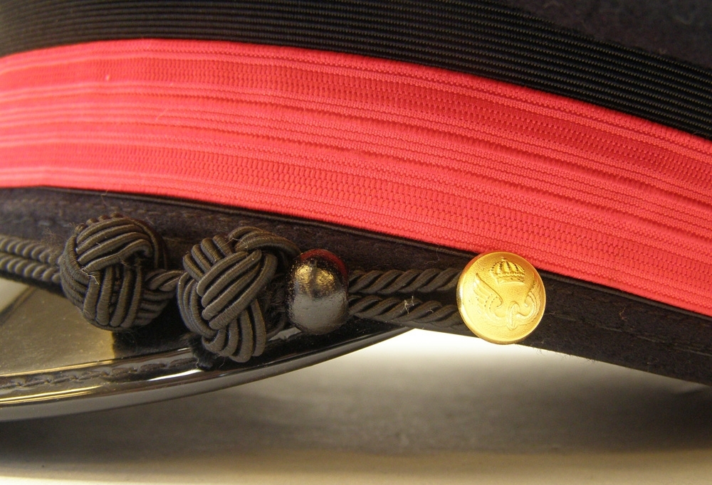 Skärmmössa av mörkblått kläde med 20 mm högrött resårband (tågklarerartecken) ovanpå ett svart mössband.
Mössmärke: krönt SJ

Själva mössmodellen är av 1940-talstyp.