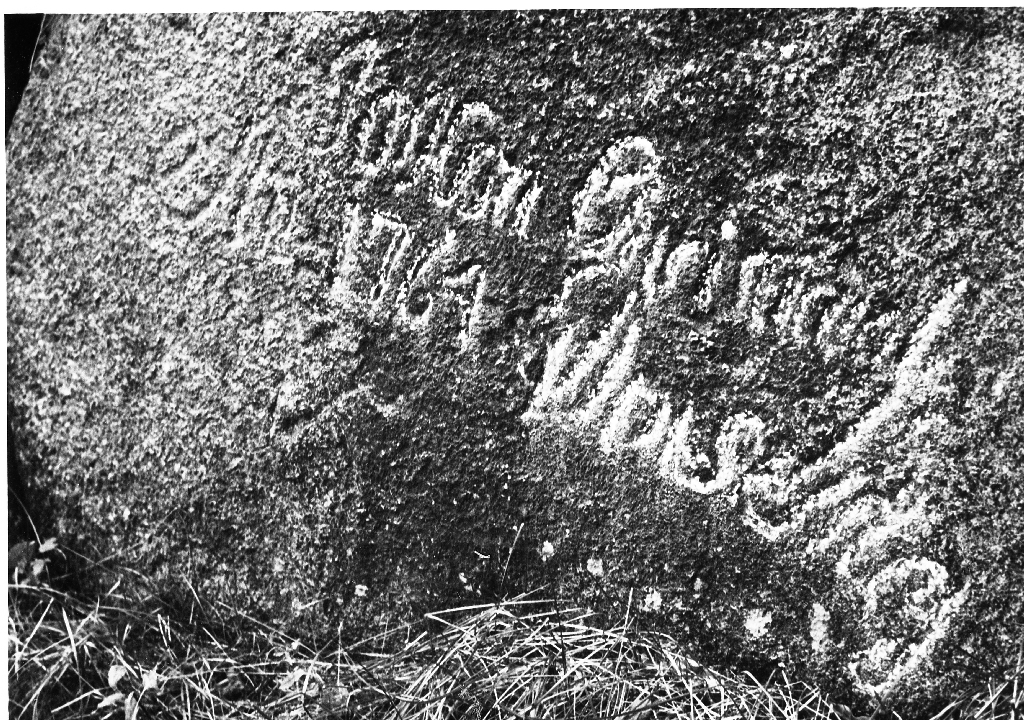 Stein med innhogd tekst. Årstalet 1764 er tydeleg - det andre er uråd å skjøna. Steinen ligg på garden til Sven T. Garborg i nærleiken av kopargruva.