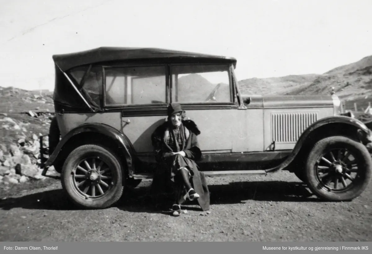 Honningsvåg. Themine Hansine Damm Olsen foran en lys Oldsmobile med kalesje. (Se kommentarer helt nederst.) 1930-tallet.