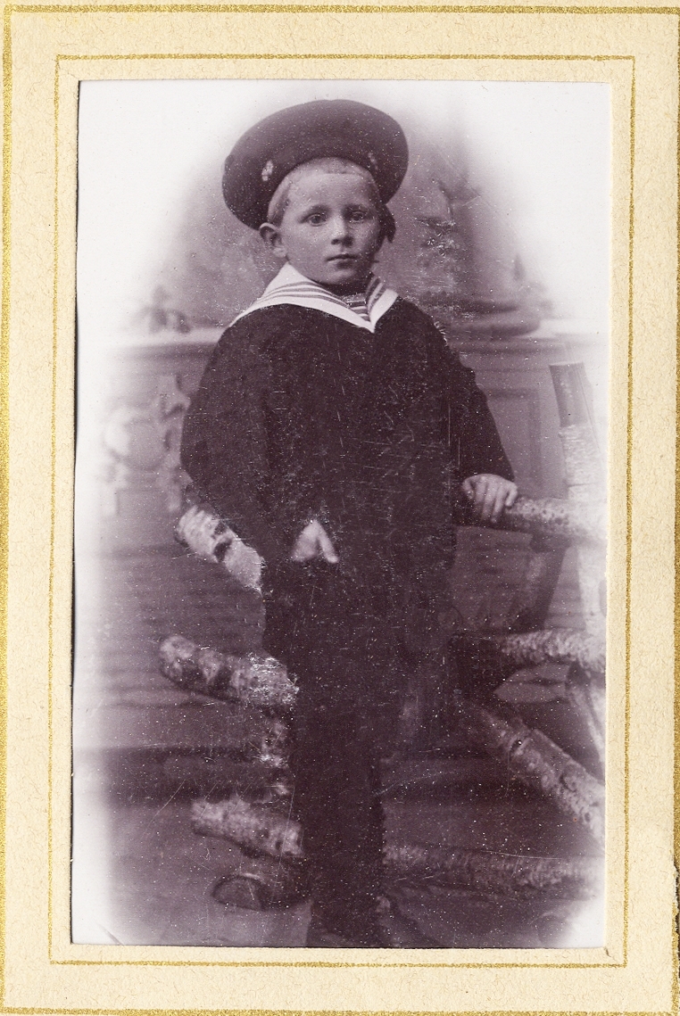 En okänd pojke i mörk sjömanskostym med hatt. 
Helfigur. Ateljéfoto.