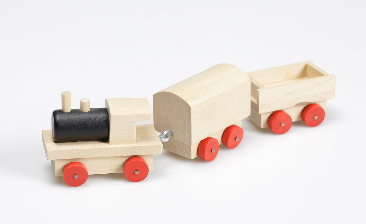 Leksakståg, av omålad björk. Hjulen är rödmålade, ångpannan är svart. Tåget består av lokomotiv med två vagnar. En vagn är täckt och en är öppen. Kopplingarna mellan vagnarna består av metallkrokar. Tåget är gjort efter gammal förebild.

Inskrivet i huvudkatalog 1981.