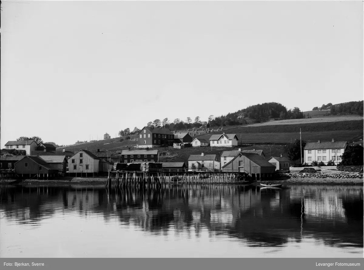 Kystlandskap  med  bebyggelse og brygger, Leksvik?