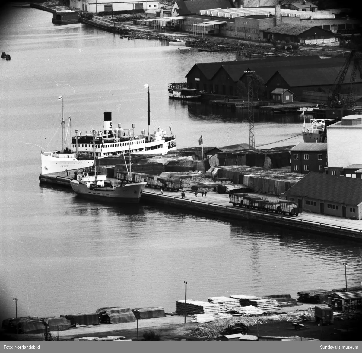 Bilder över hamnen med fryshuset, båten Ragne som ligger vid kaj, Rosenborgsmagasinen och vidare mot Skönsmon. Fotograferat med teleobjektiv från Norra berget.