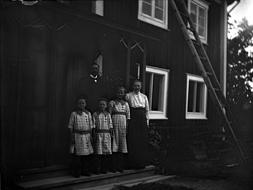 Familj, par med tre flickor på veranda.