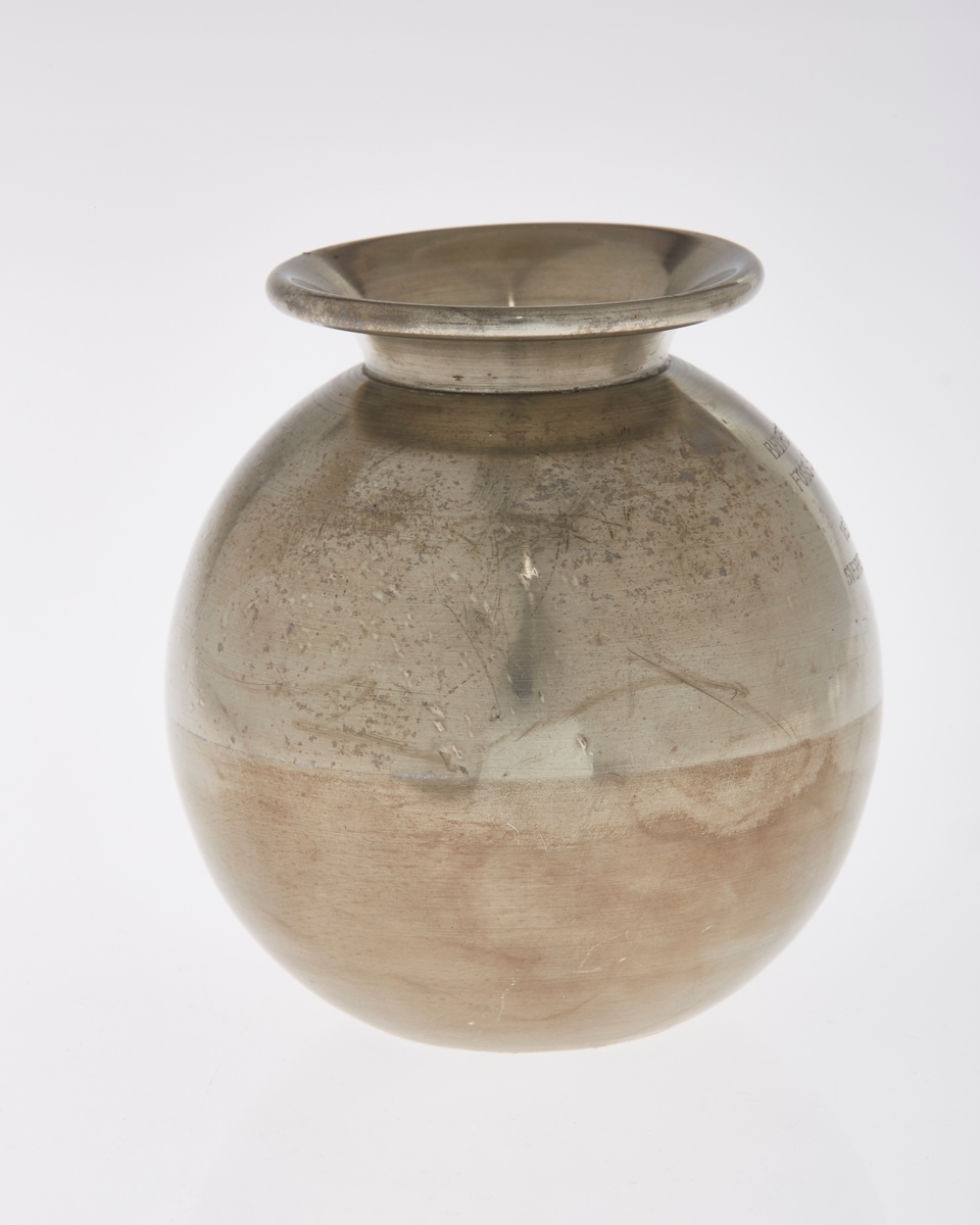 Kuleformet vase med utkraget kant rundt åpning. Inngravert tekst